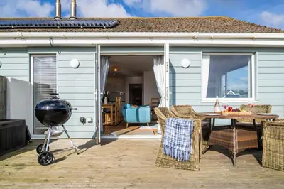a patio with a grill and a table and chairs at The Rockpool in Praa Sands
