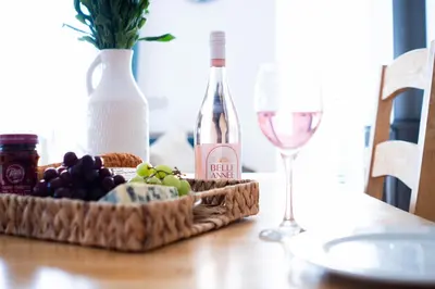 a table with a bottle of wine and a basket of grapes at The Rockpool in Praa Sands
