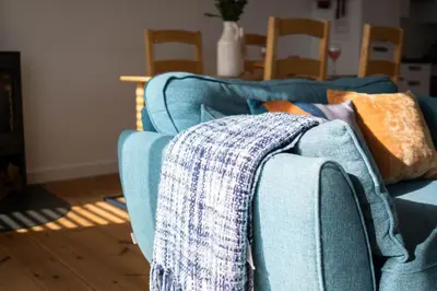 a blue couch with a blanket on top of it at The Rockpool in Praa Sands