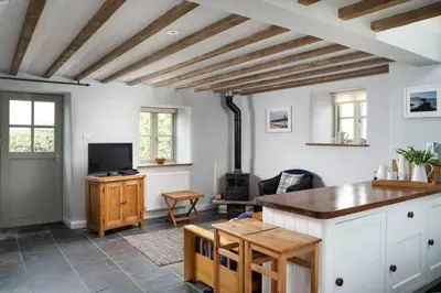 a living room with a table and a stove at Rosewall Cottage in St Ives