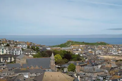 a city with houses and the ocean in the background at Skylar in St Ives