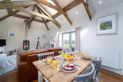 a kitchen and living room with a wooden table with fruit on it at Upper Trowan in St Ives