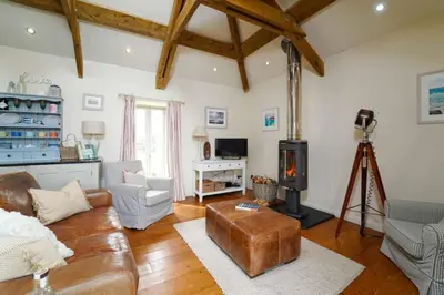 a living room with a leather couch and a fireplace at Upper Trowan in St Ives