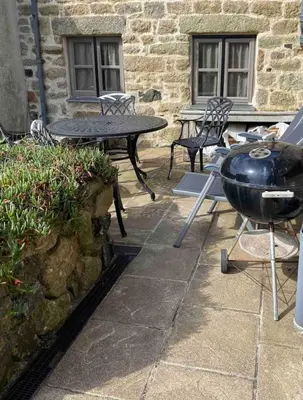 a grill and a table and chairs on a patio at Quick's Cottage in St Ives