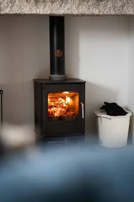 a stove in a room with a trash can at Quick's Cottage in St Ives