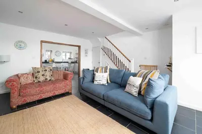 a living room with a blue couch and a chair at Quick's Cottage in St Ives