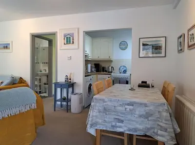 a kitchen and dining room with a table and chairs at 2-bed flat with balcony in Wadebridge