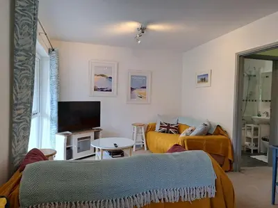 a living room with a couch and a tv at 2-bed flat with balcony in Wadebridge