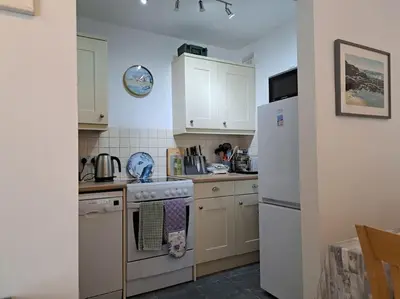 a kitchen with a stove and a refrigerator at 2-bed flat with balcony in Wadebridge