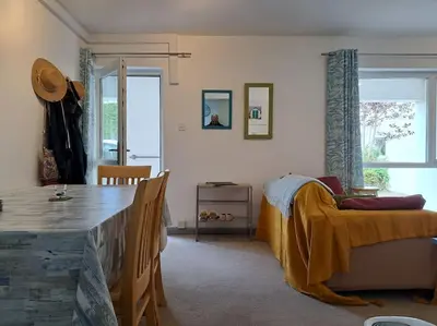a living room with a table and a couch and a dining room at 2-bed flat with balcony in Wadebridge