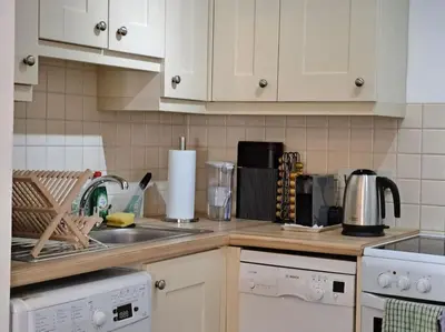 a kitchen with white cabinets and a counter top at 2-bed flat with balcony in Wadebridge
