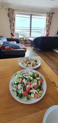 two plates of food sitting on a wooden table at Harbour Tavern Penthouse in Mevagissey