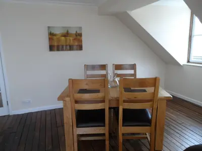 a dining room with a table and two chairs at Harbour Tavern Penthouse in Mevagissey