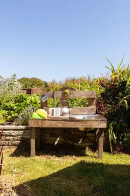 a wooden table with a sink in a garden at Good Life on the Coast in Falmouth