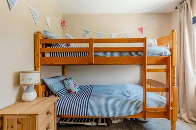 two bunk beds in a room with a table at Good Life on the Coast in Falmouth