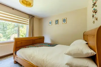 a bedroom with a wooden bed and a window at Good Life on the Coast in Falmouth