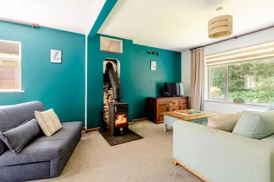 a living room with a couch and a wood stove at Good Life on the Coast in Falmouth