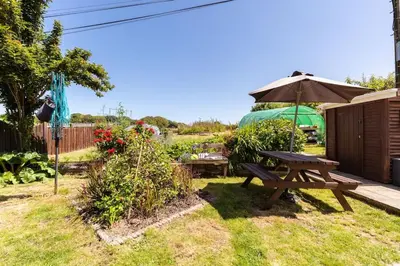a picnic table and an umbrella in a yard at Good Life on the Coast in Falmouth