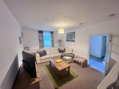 a living room with a couch and a tv at Historic Fowey Home by the Quay in Fowey