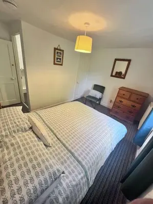 a bedroom with a bed and a dresser in it at Historic Fowey Home by the Quay in Fowey