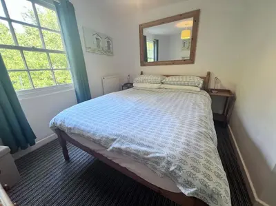 a bedroom with a bed with a mirror on the wall at Historic Fowey Home by the Quay in Fowey