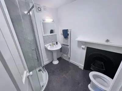 a bathroom with a shower toilet and a sink at Historic Fowey Home by the Quay in Fowey