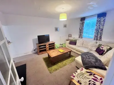 a living room with a couch and a tv at Historic Fowey Home by the Quay in Fowey
