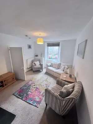 a living room with two chairs and a couch at Historic Fowey Home by the Quay in Fowey