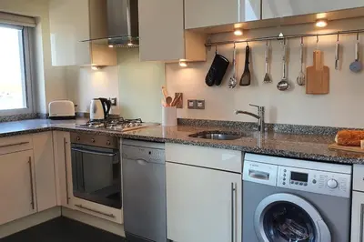 a kitchen with a sink and a dishwasher at 6 Porth Sands Newquay Cornwall Luxury with Sea Views in Newquay