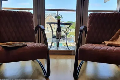 two chairs and a table in front of a window at 6 Porth Sands Newquay Cornwall Luxury with Sea Views in Newquay