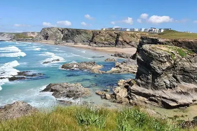 a view of a beach with rocks and the ocean at 6 Porth Sands Newquay Cornwall Luxury with Sea Views in Newquay