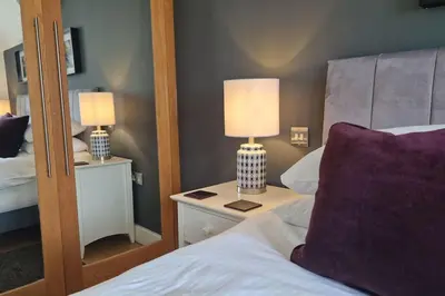 a bedroom with a bed and two lamps on a night stand at 6 Porth Sands Newquay Cornwall Luxury with Sea Views in Newquay