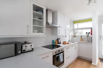 a white kitchen with white cabinets and a microwave at 24 Piazza in St Ives
