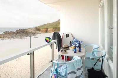 a room with a balcony with a view of the beach at 11 Barnaloft in St Ives