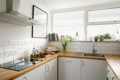 a kitchen with white cabinets and a sink and a window at 11 Barnaloft in St Ives