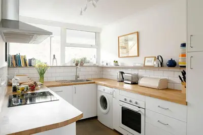 a white kitchen with a sink and a dishwasher at 11 Barnaloft in St Ives
