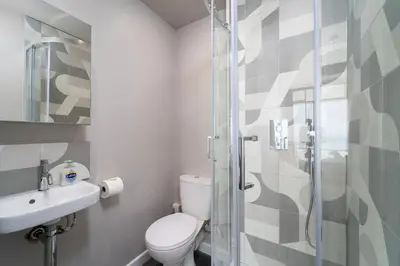 a bathroom with a toilet and a glass shower at 11 Barnaloft in St Ives