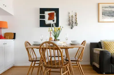 a dining room table and chairs in a room with a couch at 11 Barnaloft in St Ives