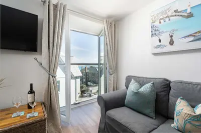 a living room with a couch and a large window at 8 Sunday School Court in St Ives