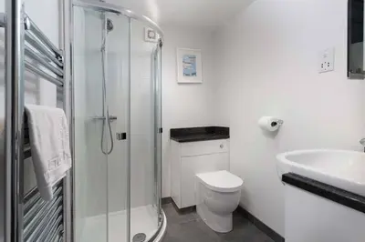 a bathroom with a shower and a toilet and a sink at 8 Sunday School Court in St Ives