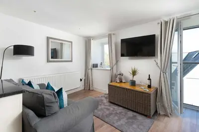 a living room with a couch and a tv at 8 Sunday School Court in St Ives
