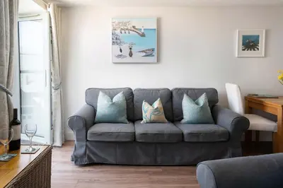 a living room with a gray couch with blue pillows at 8 Sunday School Court in St Ives