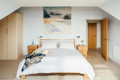a bedroom with a bed and a painting on the wall at Bodeeve in Penzance