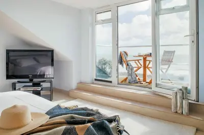 a bedroom with a large window with a view of the ocean at Bodeeve in Penzance