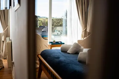 a bedroom with a bed with two pillows and a window at The Cove in Praa Sands