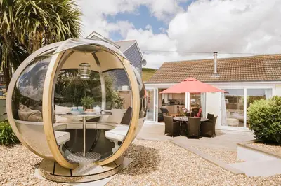 a large circular mirror in the yard of a house at The Cove in Praa Sands