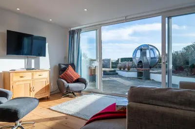 a living room with a large sliding glass door at The Cove in Praa Sands