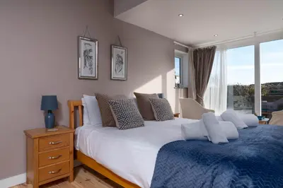 a bedroom with two beds and a window at The Cove in Praa Sands