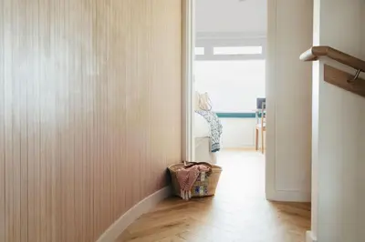 a hallway with a mirror and a basket on the floor at 6 Barnaloft in St Ives