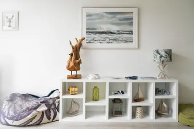 a white shelf with vases and a picture on the wall at Seasky in Praa Sands
